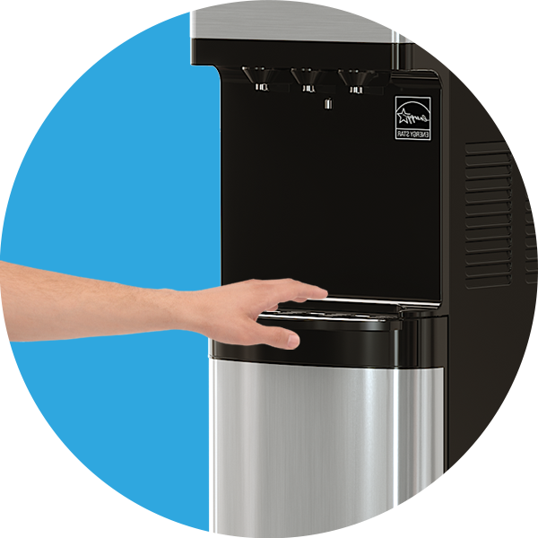 A hand reaches to place a cup under the dispenser of a stainless steel and black water and ice machine against a blue background.